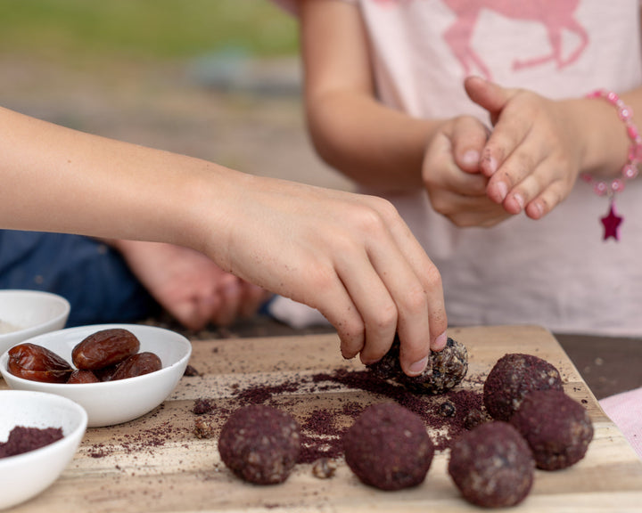 Kinderhände formen Energy Balls mit Datteln und nordischem Beerenpulver