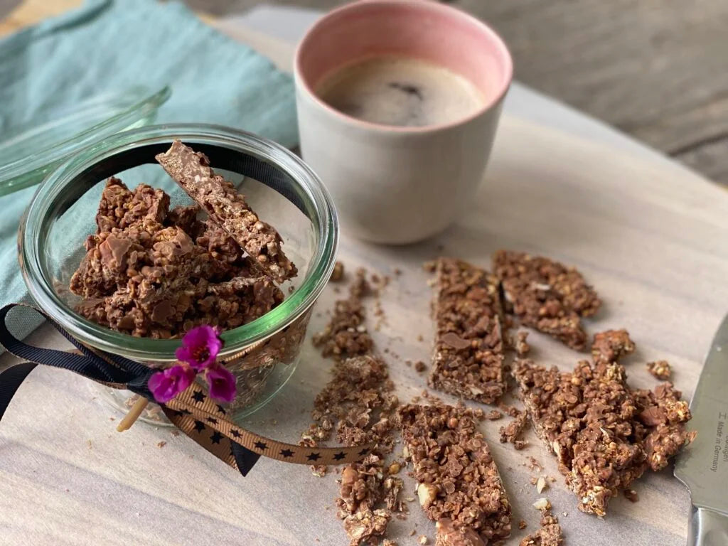 Schoko- Sanddorn Granola in Schale mit Kaffee auf Tisch