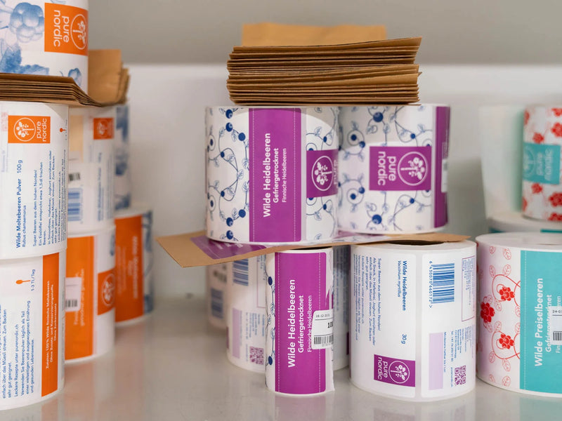 Rollen mit Pure Nordic-Beerenetiketten und braunen Papiertüten.