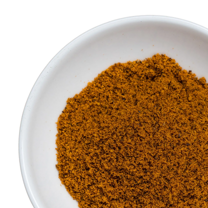 Eine weiße Schüssel, gefüllt mit getrocknetem Sanddornpulver.