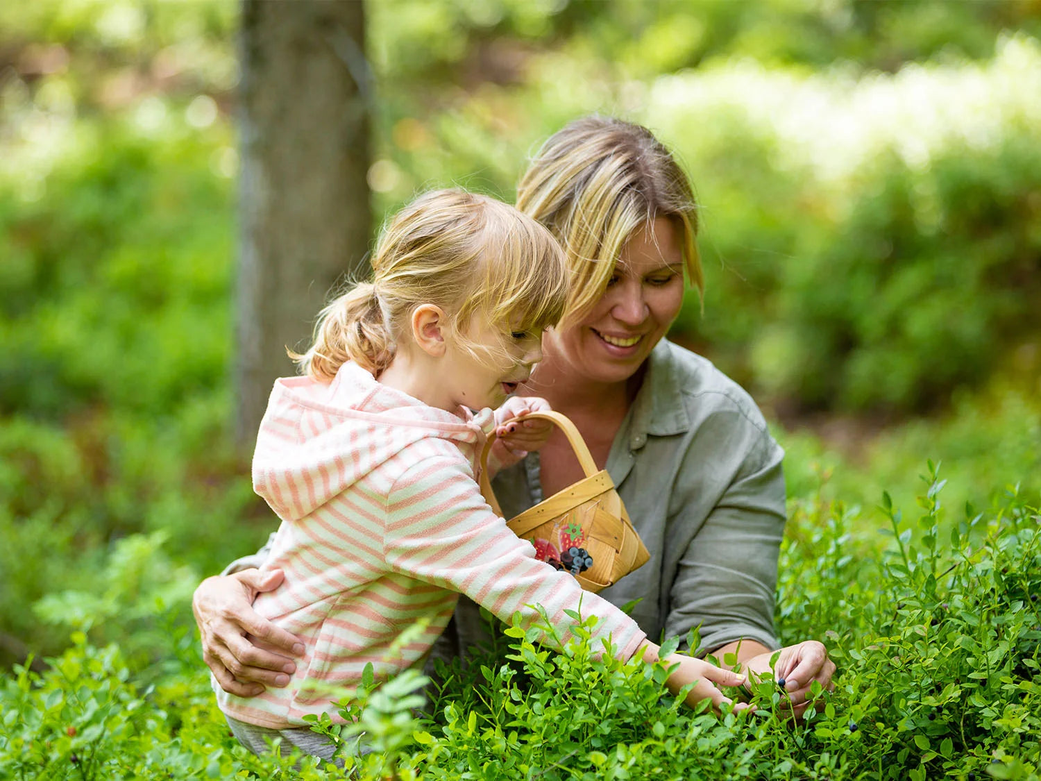 Eva und ihre Tochter pflücken Beeren im finnischen Wald.