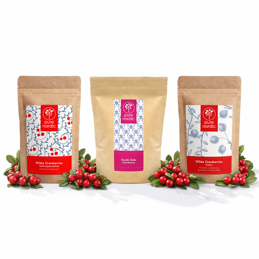 Dre Pure Nordic Beutel mit Cranberries und Haferflocken, umgeben von roten Beeren.